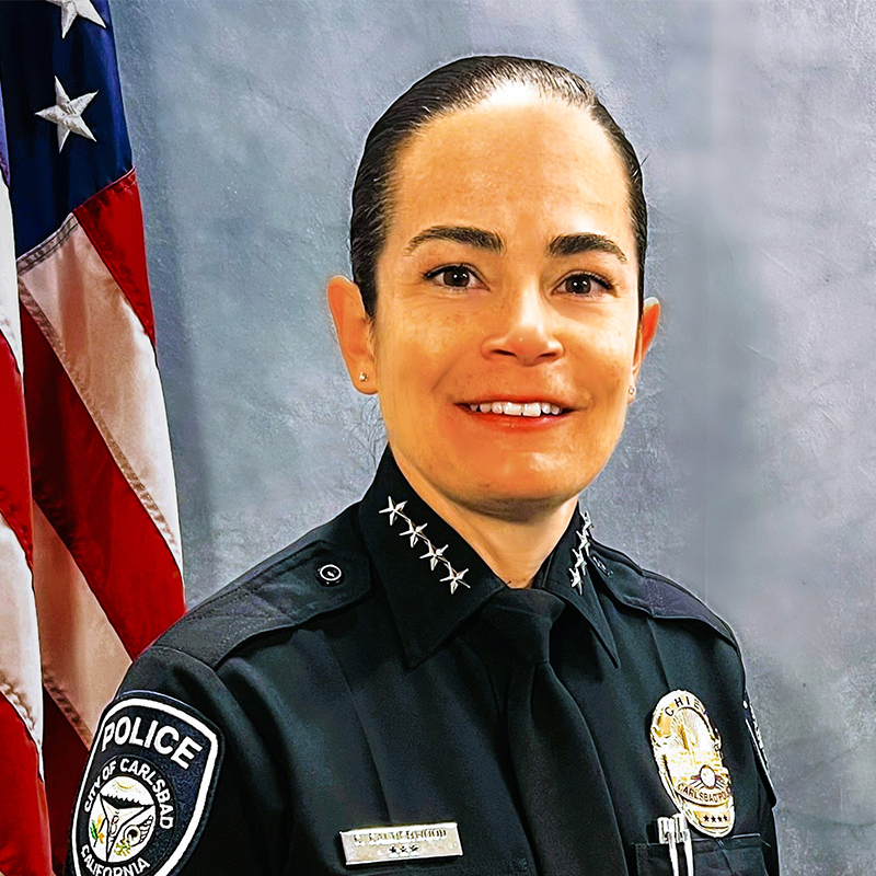 Chief Christie Calderwood in uniform, in front of an American flag.